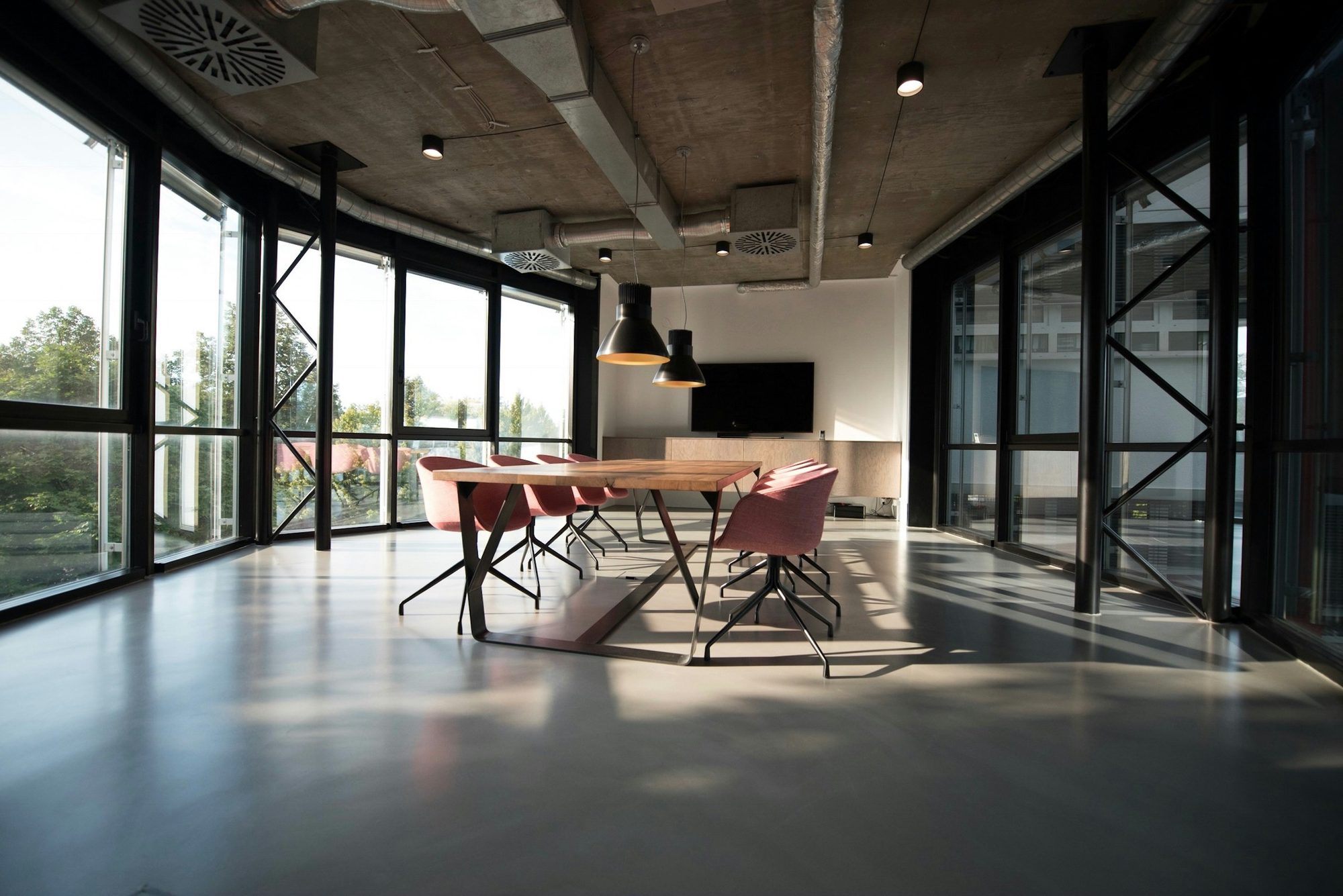 A modern office interior with a meeting table and glass partitions